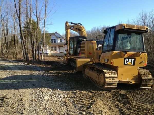 bulldozer and crane with house in background